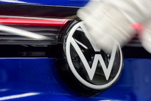 A technician cleans a Volkswagen logo at the production line for electric car models of the Volkswagen Group, in Zwickau, Germany, April 26, 2022.