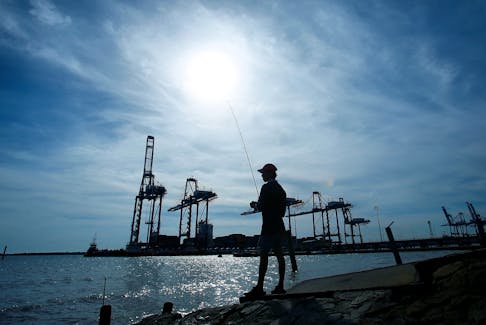 A man is silhouetted as he fishes near Northport in Klang outside Kuala Lumpur June 6, 2014.