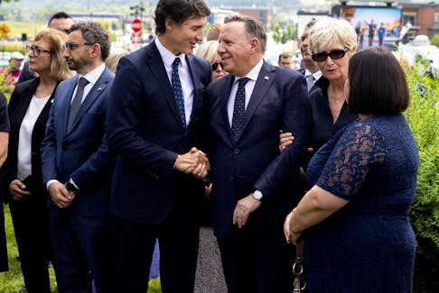 Canadian Prime Minister Justin Trudeau, speaks with Quebec Premier Francois Legault, after a ceremony to mark the tenth anniversary of a rail disaster that killed 47 people, where a train carrying crude oil crashed into the centre of Lac-Megantic, Quebec, Canada July 6, 2023. 