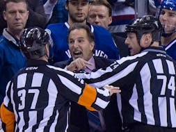  Referees get in the way of then-Vancouver Canucks head coach John Tortorella as he screams at the Calgary Flames bench at Rogers Arena in Vancouver, B.C., in this file photo taken Jan. 18, 2014. Tortorella was suspended for 15 days for losing his cool.