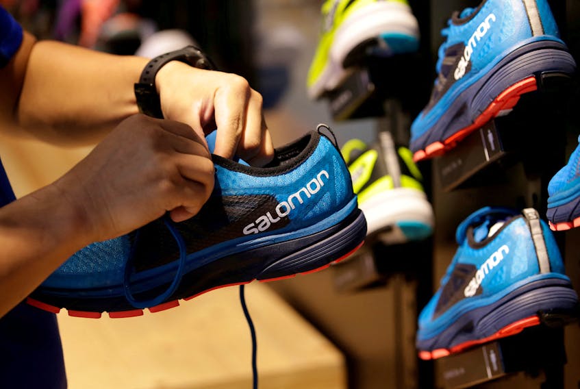 A shop assistant holds a shoe at a Salomon store in Beijing, China August 10, 2018.