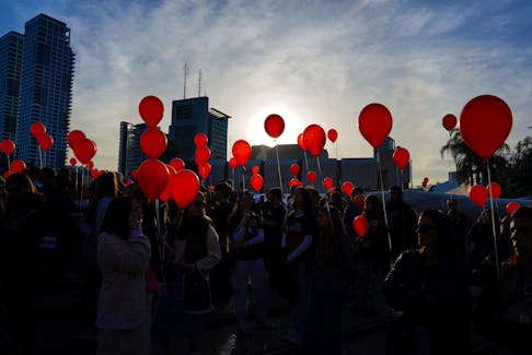 People carry balloons as relatives and supporters of Kfir Bibas, who was taken hostage along with his brother and parents on October 7, mark Kfir's first birthday as he is being held in captivity by Palestinian Islamist group Hamas in the Gaza Strip, at an event in Tel Aviv, Israel, January 18, 2024.