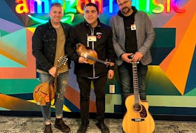 From left, Ryan Roberts, Morgan Toney and Keith Mullins stand in front of the Amazon Music logo in the company's 47th floor office in Scotia Plaza in Toronto. Toney is nominated for three East Coast Music Awards, Fusion Recording of the Year, Roots/Traditional Recording of the Year, and Indigenous Artist of the Year. Mullins is also nominated for Producer of the Year.  CONTRIBUTED/MORGAN TONEY