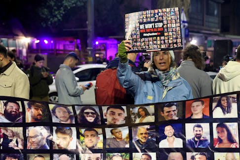A person holds a placard, as families of hostages and supporters protest to call for the immediate release of hostages kidnapped during the deadly October 7 attack by Palestinian Islamist group Hamas, outside Israeli Prime Minister Benjamin Netanyahu residence, in Jerusalem January 21, 2024.