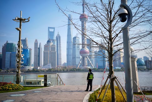 A security guard stands guard on a riverside in front of the Lujiazui financial district, during the National People's Congress (NPC) in Shanghai, China, March 7, 2023.