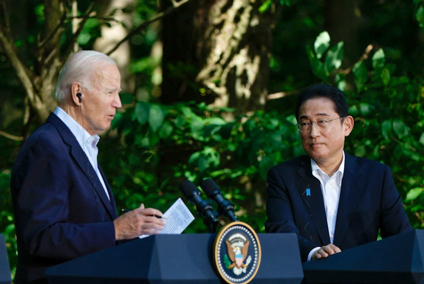 Japanese Prime Minister Fumio Kishida listens to U.S. President Joe Biden during a joint press conference with South Korean President Yoon Suk Yeol (not pictured) at the trilateral summit at Camp David near Thurmont, Maryland, U.S., August 18, 2023.