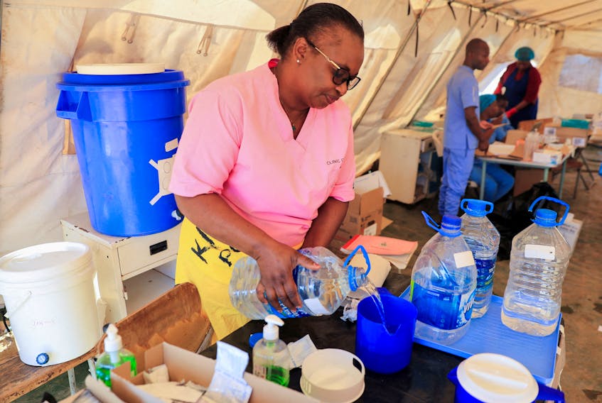 A health worker prepares a solution inside a tent for cholera patients at Kuwadzana Polyclinic in Harare, Zimbabwe November 24, 2023.