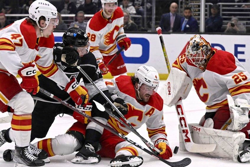 Calgary Flames goaltender Jacob Markstrom, right, blocks a shot by Los Angeles Kings center Blake Lizotte in Los Angeles, Saturday, Dec. 23, 2023.