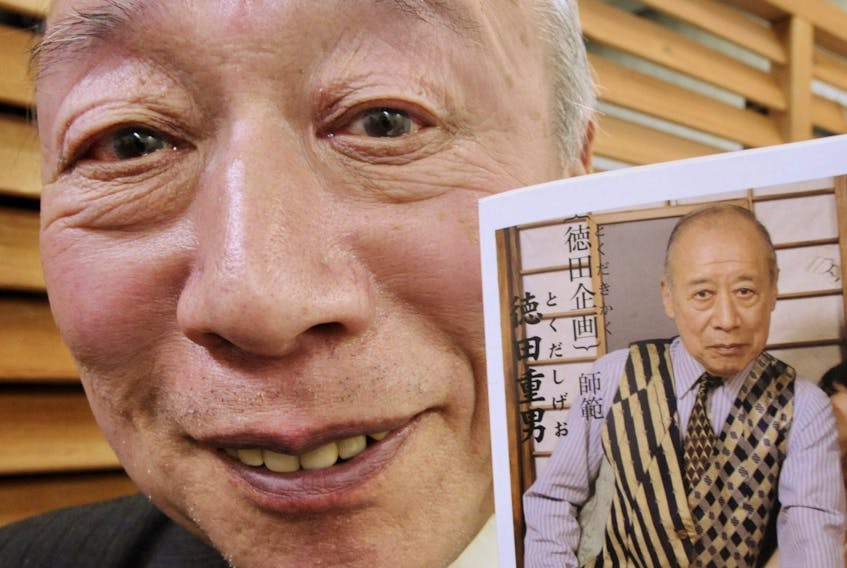 Porno video actor Shigeo Tokuda smiles as he shows an advertisement poster of his video at a Tokyo video shop on March 5, 2009. 