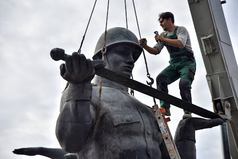 A worker dismantles the Monument to the War Glory of the Soviet Army following a decision by local authorities in Lviv, Ukraine July 23, 2021. 
