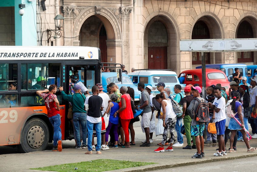 People gather at a bus stop as the government announced it will hike the retail price of its 94 octane gasoline from 30 to 156 pesos per litre beginning February 1, in Havana, Cuba January 11, 2024.