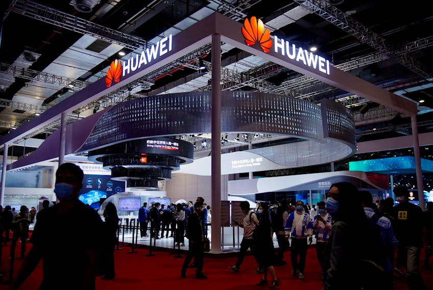 Visitors walk past the Huawei booth during a media day for the Auto Shanghai show in Shanghai, China April 19, 2021.
