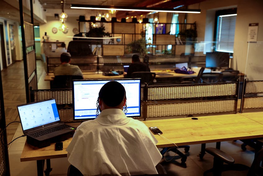 Men work at the offices of a co-working space run by Bizmax, an innovation center for Ultra-Orthodox Jewish male residents of Jerusalem, January 3, 2023.