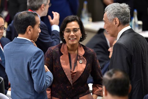 Singapore's Prime Minister Lee Hsien Loong (R) talks with Indonesia's President Joko Widodo (L) and Finance Minister Sri Mulyani Indrawati (C) prior to the session 3 on women's workforce participation, future of work, and ageing societies at the G20 Summit in Osaka June 29, 2019. Kazuhiro Nogi/Pool via