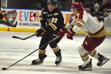 Olivier Houde of the Cape Breton Eagles, left, dumps the puck into the offensive zone as he’s pressured by Drew Maddigan of the Acadie-Bathurst Titan during Quebec Major Junior Hockey League action at Centre 200 in Sydney earlier this season. JEREMY FRASER/CAPE BRETON POST