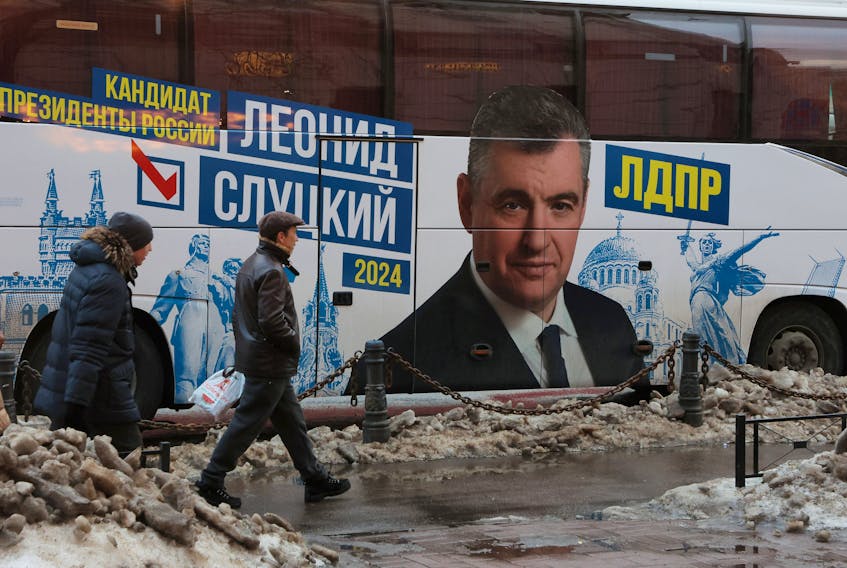 People walk past a bus with a portrait of Leonid Slutsky, leader of the Russia's Liberal Democratic Party (LDPR) and presidential candidate for the upcoming 2024 election, in Saint Petersburg, Russia February 1, 2024. 