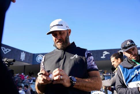Feb 10, 2024; Las Vegas, Nevada, USA; Dustin Johnson signs golf balls after winning the individual championship during the final round of the LIV Golf Las Vegas tournament at Las Vegas Country Club. Mandatory Credit: Lucas Peltier-USA TODAY Sports