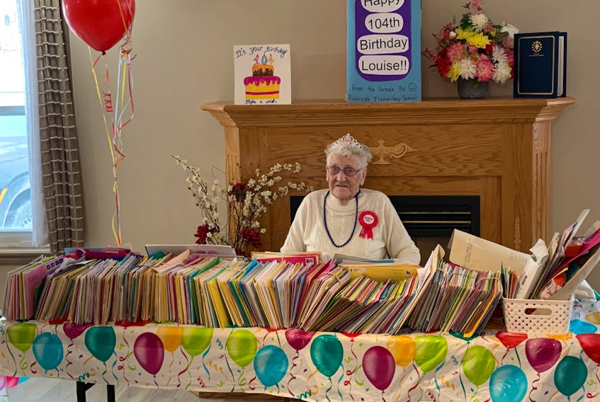 Louise Pelley, a resident at the Clarenville Retirement Centre, poses with the more than 1,500 birthday cards she received for her 104th birthday on Feb. 1. – Contributed