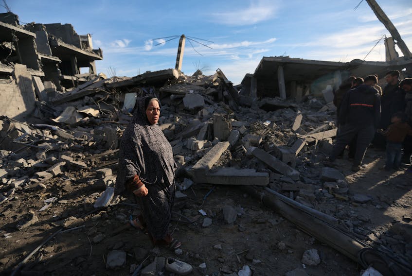 A Palestinian woman walks at the site of an Israeli strike on a house, amid the ongoing conflict between Israel and the Palestinian Islamist group Hamas, in Rafah in the southern Gaza Strip, February 12, 2024.