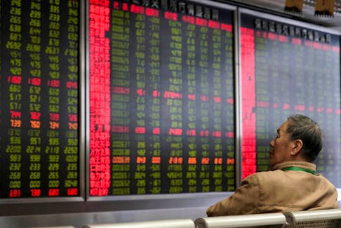 An investor watches a board showing stock information at a brokerage office in Beijing, China October 8, 2018.