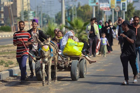 Palestinian civilians ride a donkey-drawn cart as they evacuate from the north of the Gaza Strip towards south, amid the ongoing conflict between Israel and Palestinian Islamist group Hamas, in the central Gaza Strip November 7, 2023.