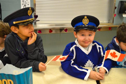 Alex Smith, 7, left, and Curtis Christmas, 7, tried on the hats of visiting Cape Breton Regional Police Service officers. Chris Connors/Cape Breton Post