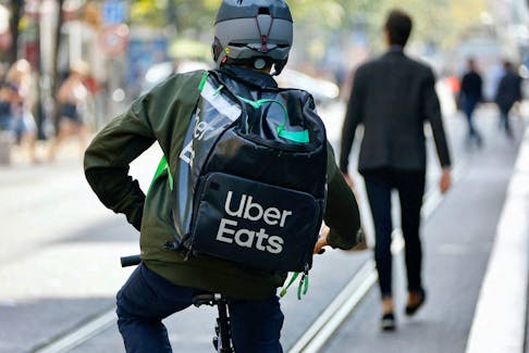 A delivery worker with a backpack of Uber Eats rides a bike in Nice, France, October 25, 2022. 
