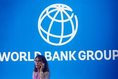 A participant stands near a logo of World Bank at the International Monetary Fund - World Bank Annual Meeting 2018 in Nusa Dua, Bali, Indonesia, October 12, 2018.