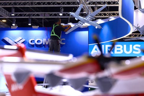 A worker fixes cables at the Comac booth ahead of the Singapore Airshow at Changi Exhibition Centre in Singapore February 18, 2024.