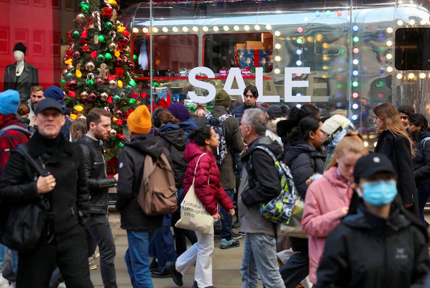 Shoppers walks past sale signage on Regent Street during the Boxing Day sales, in London, Britain, December 29, 2023.