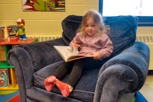 Brooklyn Linthorne enjoys a free new picture book, from Adopt-a-Library Literacy Program (free to take home), curled up in a cozy chair at the Westville Library after Friday morning Family Storytime. Contributed