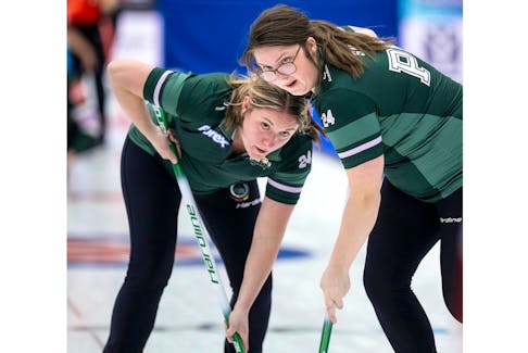 P.E.I. lead Whitney Jenkins, left, and second stone Sabrina Smith, right, sweep a rock during a game against Team Canada’s Kerri Einarson rink at the Scotties Tournament of Hearts in Calgary on Feb. 19. Team Canada won the game 10-4. - Andrew Klaver/Curling Canada