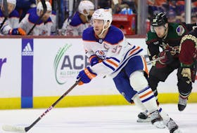 Connor McDavid (97) of the Edmonton Oilers skates with the puck past Barrett Hayton (29) of the Arizona Coyotes at Mullett Arena on Feb. 19, 2024, in Tempe, Ariz. The Oilers defeated the Coyotes 6-3.