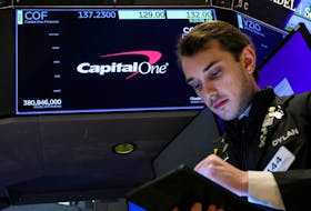 A screen displays the logo and trading information for Capital One Financial as a trader works on the floor at the New York Stock Exchange (NYSE) in New York City, U.S., February 20, 2024. 