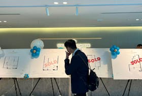 A buyer looks at signs of successful sales of off-the-plan apartments at The Parkside, in Macquarie Park, Sydney, Australia, February 25, 2023.