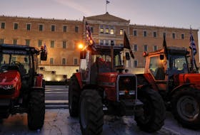 Farmers rest in their tractors, after spending the night outside the parliament in Athens in a push for more measures by the government over high production costs in Athens, Greece, February 21, 2024.
