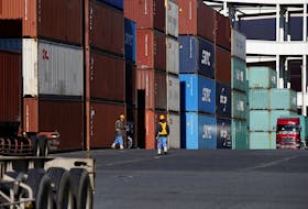 Workers walk in a container area at a port in Tokyo, Japan January 25, 2016.