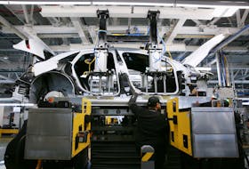 Workers marry the body structure with the battery pack and the front and rear sub frames as they assemble electric vehicles at the Lucid Motors plant in Casa Grande, Arizona, U.S. September 28, 2021. 