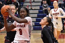 Acadia Axewomen forward Elizabeth Iseyemi drives to the basket against the defence of Alaina McMillan (right) of Saint Mary's during an Atlantic university women's basketball game on Feb. 10 in Wolfville. - Acadia Athletics