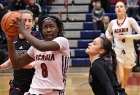 Acadia Axewomen forward Elizabeth Iseyemi drives to the basket against the defence of Alaina McMillan (right) of Saint Mary's during an Atlantic university women's basketball game on Feb. 10 in Wolfville. - Acadia Athletics