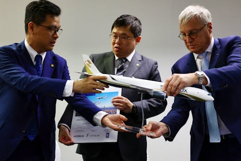 Starlux CEO Glenn Chai, Chairman Chang Kuo-wei and Airbus Commercial Aircraft CEO Christian Scherer prepare to pose for group photos during a signing ceremony at the Singapore Airshow at Changi Exhibition Centre in Singapore February 21, 2024.