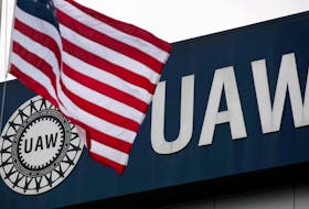An American flag flies in front of the United Auto Workers union logo on the front of the UAW Solidarity House in Detroit, Michigan, September 8, 2011.