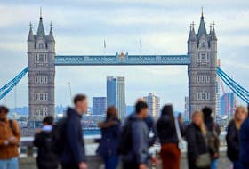 People walk over London Bridge looking at a view of Tower Bridge in the City of London financial district in London, Britain, October 25, 2023. 