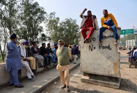 Farmers sit on a concrete block, during a protest demanding better crop prices, promised to them in 2021, at Shambhu Barrier, a border crossing between Punjab and Haryana states, India, February 20, 2024.