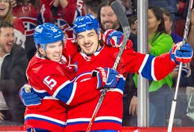 Canadiens's Alex Newhook, left, congratulates Arber Xhekaj after the defenceman scored the opening goal Wednesday night against the Sabres at the Bell Centre. 