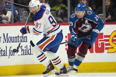 Edmonton Oilers' Connor McDavid collects the puck as Colorado Avalanche centre Nathan MacKinnon pursues.