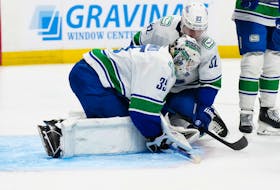 Feb 20, 2024; Denver, Colorado, USA; Vancouver Canucks goaltender Thatcher Demko (35) and defenseman Ian Cole (82) cover up a loose puck in the second period against the Colorado Avalanche at Ball Arena. Mandatory Credit: Ron Chenoy-USA TODAY Sports
