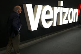 A man stands next to the logo of Verizon at the Mobile World Congress in Barcelona, Spain, February 26, 2019.