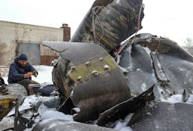 A man photographs parts of an unidentified missile, which Ukrainian authorities believe to be made in North Korea and was used in a strike in Kharkiv earlier this week, amid Russia's attack on Ukraine, in Kharkiv, Ukraine January 6, 2024.
