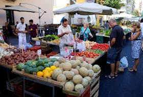 People buy fruit and vegetables in a street market in Rome, Italy, August 11, 2016. Picture taken August 11, 2016.